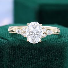 a diamond ring sitting on top of a green velvet cushion