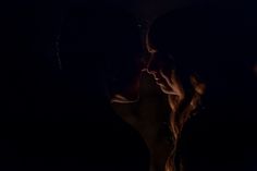 two people are kissing in the dark