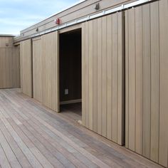 an open door on the side of a building with wooden flooring and sidings