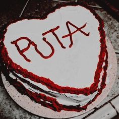 a heart shaped cake with the word psta written on it in red icing