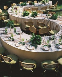 a circular table is set up with chairs and place settings for an outdoor dinner party