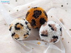 three crocheted balls sitting on top of a white cloth covered table next to stars