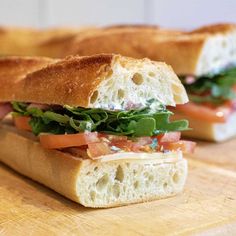 two sandwiches are sitting on a cutting board