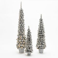 three small christmas trees with lights in them on a white background, one is silver and the other is gold