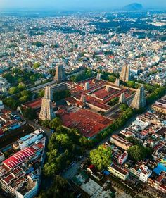 an aerial view of a city with lots of buildings and trees in the foreground