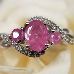 Ilakaka, Pink Sapphire, Zircon, Ring. Size (7) Platinum Over Sterling Silver (1.65) Ctw. Fissure Filled, Pink Sapphire. Oval (75) Mm. Zircon Rounds (1) Mm. Prong Setting. Wavy Shank. Finished Under Gallery. Beautiful, Elegant, Hypoallergenic. September Birthstone. Promise Ring. Traditional Gift For 5th And 45th Anniversary New Gift Box Included. Anniversary Rings With Pink Sapphire And Gemstone Accents, Anniversary Pink Sapphire Rings With Gemstone Accents, Pink Sapphire Rings With Gemstone Accents, Pink Sapphire Ring With Accent Stones, Silver Jewelry With Pink Sapphire Accent Stones, Pink Sapphire Cluster Ring As A Gift, Pink Sapphire Rings With Gemstone Accents Gift, Pink Sapphire Ring For Gift, Silver Rings With Pink Sapphire Birthstone