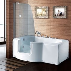 a bath tub sitting next to a wall with pictures on the wall behind it and a wooden floor