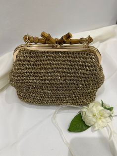 Hand-knitted women's bag, made with high quality raffia yarn.  The bag has satin interior pocket and bamboo belt.  Carry elegance everywhere with this Minell bag SIZE: 22x16x15 centimeters - 8.7 x 6.3 x 5.9 inches Do not wash in washing machine. Please feel free to contact us for any questions you have for this product. Products will be disinfected and sent Gold Rectangular Handwoven Crochet Bag, Handmade Straw Crochet Handheld Bag, Handmade Handheld Straw Crochet Bag, Handmade Handheld Crochet Straw Bag, Handheld Crochet Straw Bag Handmade, Gold Rectangular Crochet Bag With Braided Handles, Gold Woven Straw Bags, Woven Yarn Shoulder Bag, Elegant Jute Crochet Bag