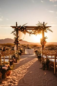 an outdoor wedding set up in the desert with flowers and greenery on the aisle