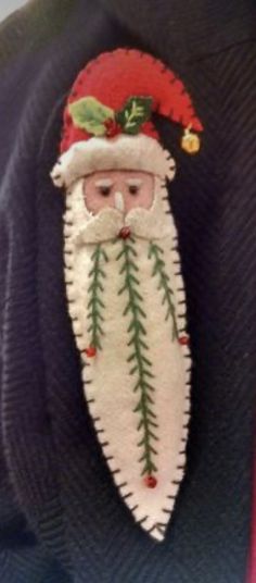 a santa clause ornament hanging from the back of someone's sweater,