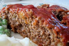 meatloaf with sauce and green beans on a plate