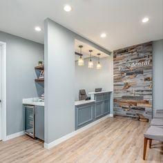 an empty office with wooden floors and gray walls, along with a white counter top