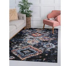 a living room area with a couch, chair and rug on the floor in front of a white wall