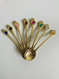 a gold brooch with six different colored stones