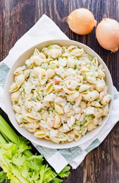 a white bowl filled with macaroni salad next to celery