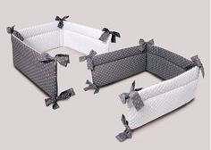 three baby cribs with bows on the top and bottom, one in grey