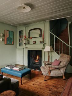 a living room filled with furniture and a fire place next to a stair case in front of a fireplace