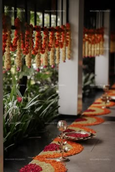 a long row of flower garlands hanging from the ceiling with candles on each side