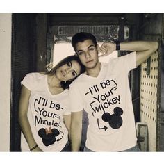 two people wearing matching shirts with mickey ears on them, one is holding his arm around the other's shoulder