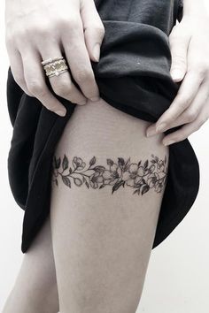 a woman is holding her thigh with flowers on it