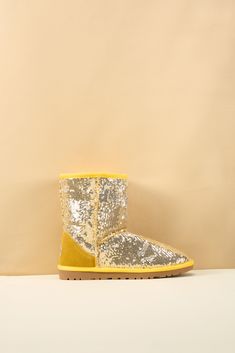 Spice up your shoe game with Smaibulun Ugg's Dallas Glam Sequin Shearling Boots! The perfect blend of style and comfort, these boots feature playful yellow glam sequins and cozy shearling lining. Who says ugg footwear has to be boring? (No one, that's who!) 1'' heel 7.6'' shaft 15.8'' circumference Pull-on Suede upper & Man-made sequins Faux fur lining EVA sole