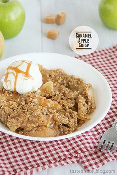 an apple crisp with ice cream and caramel syrup in a white bowl on a checkered tablecloth