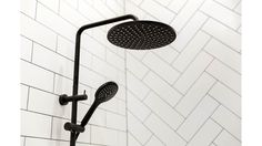 a black shower head in a white tiled bathroom