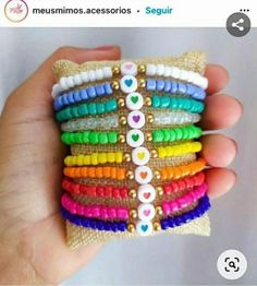 a hand holding a stack of bracelets with hearts on each strand and bead ends