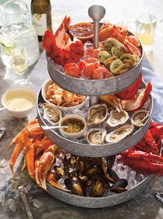 a three tiered tray filled with different types of seafood