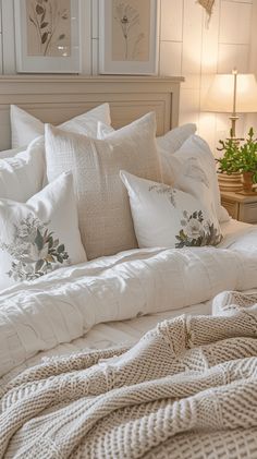 a bed with white pillows and blankets on it