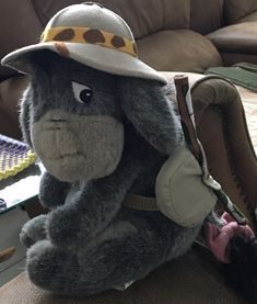 a stuffed animal wearing a hat and sitting on a chair