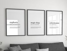 three framed posters hang on the wall above a couch in a living room with pillows