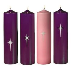 three pillar candles with stars on them in purple and pink colors, each one lit