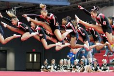 a group of cheerleaders doing tricks in the air