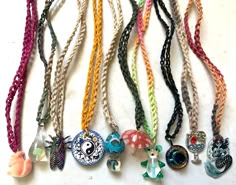 many different colored necklaces on a white surface