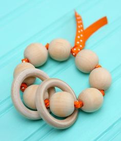 a wooden bead necklace with orange beads and an orange ribbon on a blue background