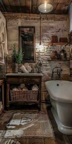 an old fashioned bathroom with exposed brick walls and wood flooring, including a claw foot tub