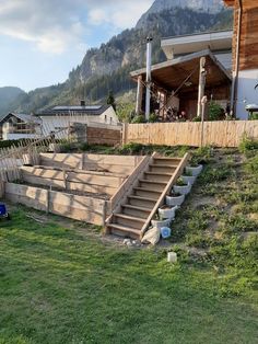 an outdoor area with steps leading up to the roof and grass in front of it