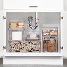 an organized pantry with various containers and items in the bottom drawer, including rolls of toilet paper