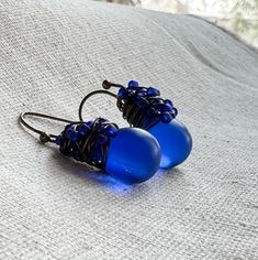 Our signature Confetti earrings are crafted with frosted glass in a stunning cobalt blue hue. The perfect mood-boosting pop of color! Hand wrapped in a whirl of matching Royal Blue Japanese seed beads and antiqued brass.  Each drop dangles from matching French hook style ear wires. These frosted beads are translucent so light creates a stunning glow. The perfect pop of color for the office, a coffee date or just running errands. * Focal: Cobalt Blue Czech Glass beads, approx. 1/2 inch tall * Met Blue Wire-wrapped Glass Earrings, Blue Glass Wire Wrapped Earrings, Blue Wire Wrapped Glass Earrings, Nickel-free Blue Recycled Glass Earrings, Blue Nickel-free Recycled Glass Earrings, Blue Recycled Glass Nickel-free Earrings, Blue Teardrop Recycled Glass Jewelry, Blue Recycled Glass Dangle Earrings, Blue Glass Earrings