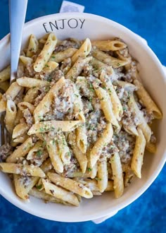 a white bowl filled with pasta and meat