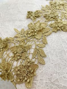 an embroidered lace with gold flowers on it