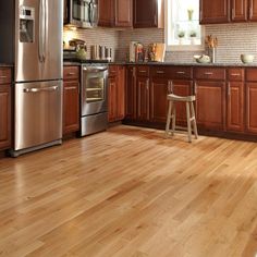 a kitchen with wooden floors and stainless steel appliances