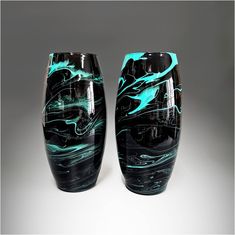 two black and blue vases sitting side by side