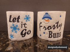 two white paper towels with the words let it go frosty buns on them