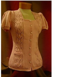 a mannequin wearing a pink cardigan with white lace on the sleeves and buttons