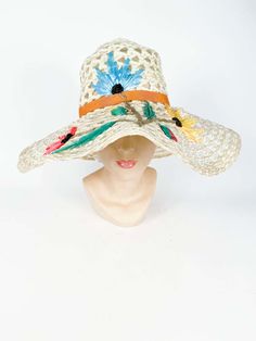 For Sale on 1stDibs - 1960s Creme Raffia Beach Hat with Raffia Flower hand-embroidery in blue, pink and yellow finished with an orange gros-grain band. Retro Handmade Crochet Beach Hat, Raffia Embroidery Couture, Summer Flower-shaped Multicolor Hat, Vintage Crochet Beach Hat, One Size, Vintage Cream Wide-brim Straw Hat, Raffia Hat, Beach Hat, Embroidery Flowers, Floppy Hat