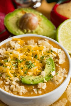 a close up of a bowl of food with tortilla chips and avocado