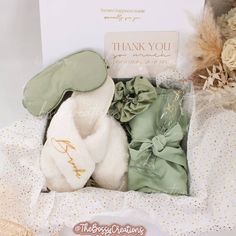 Step into a world of luxury with our Sage Green Fluffy Slippers Bridesmaid Gift Box. Designed for the modern bride who wants to spoil her bridal party, this exquisite gift box includes a sumptuous robe, a matching satin hair scrunchie and eye mask, a personalized champagne flute, and a pair of white personalized fluffy slippers. Indulge your bridesmaids in pure comfort and style as they prepare for your special day. These handmade slippers are not only cozy and soft but also customizable with each bridesmaid's name. It's the perfect keepsake to cherish long after the wedding bells have stopped ringing. But this gift box isn't just about pampering your bridal party - it's about creating beautiful memories. With color options to match your wedding theme, you can ensure that every detail is p Slippers Bridesmaid, Traditional Wedding Gifts, Boho Wedding Gifts, Personalized Champagne Flutes, Handmade Slippers, Fluffy Slippers, Bridesmaid Gift Boxes, Green Bridesmaid, Curated Gift Boxes