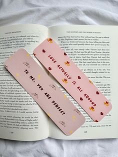 two pink bookmarks sitting on top of an open book